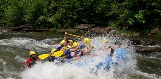 Group of people in a raft going off a wave