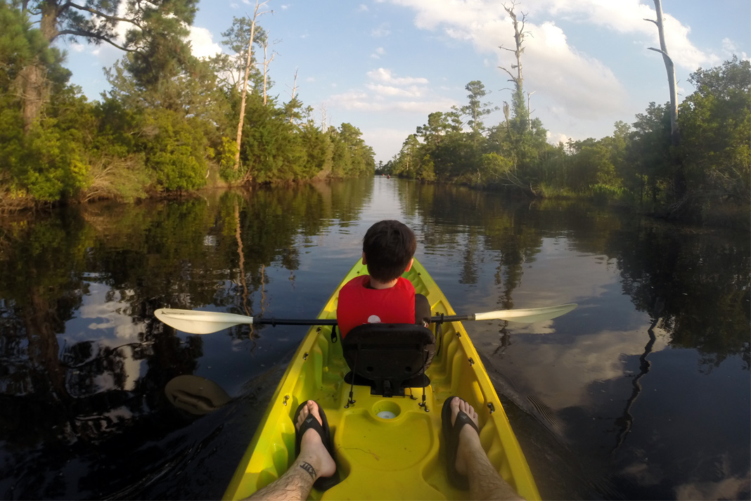 View from back of tandem kayak with small boy in front.
