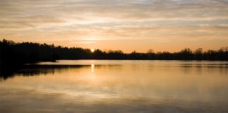 Calm lake with sun going down