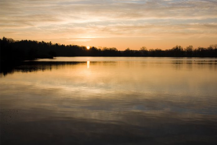 Calm lake with sun going down