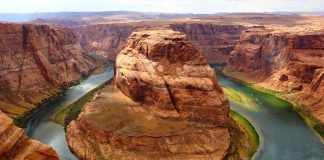 River wraps around a rock formation in the Grand Canyon