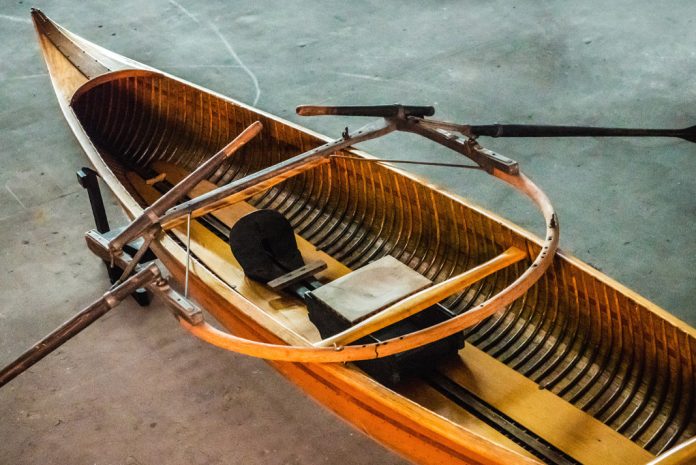Wooden canoe with set of oars