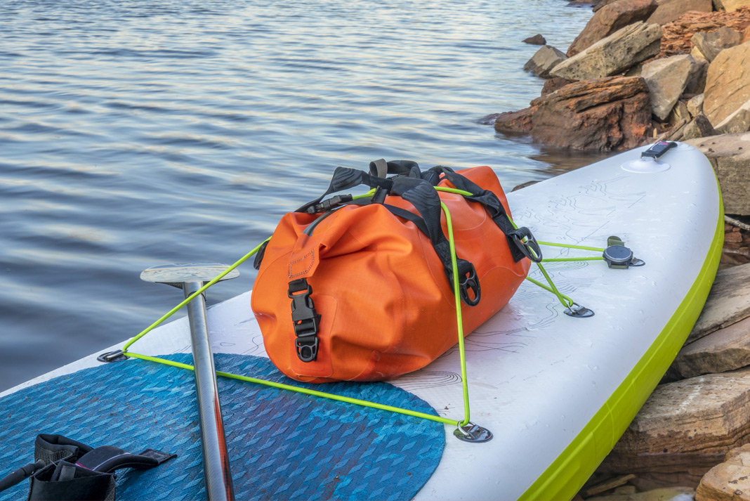 Inflatable paddleboard with bag strapped to front end