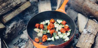 Frying pan with veggies over a fire