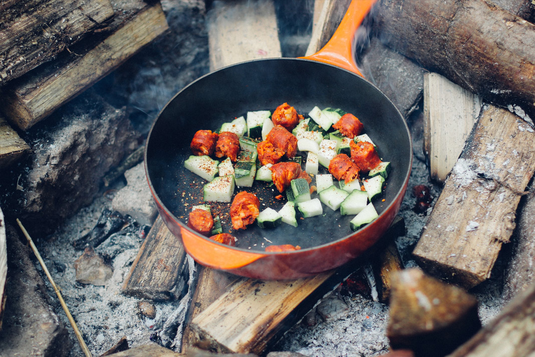 Frying pan with veggies over a fire
