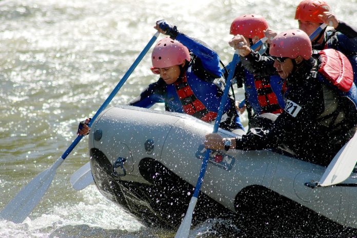 People paddling hard in a raft