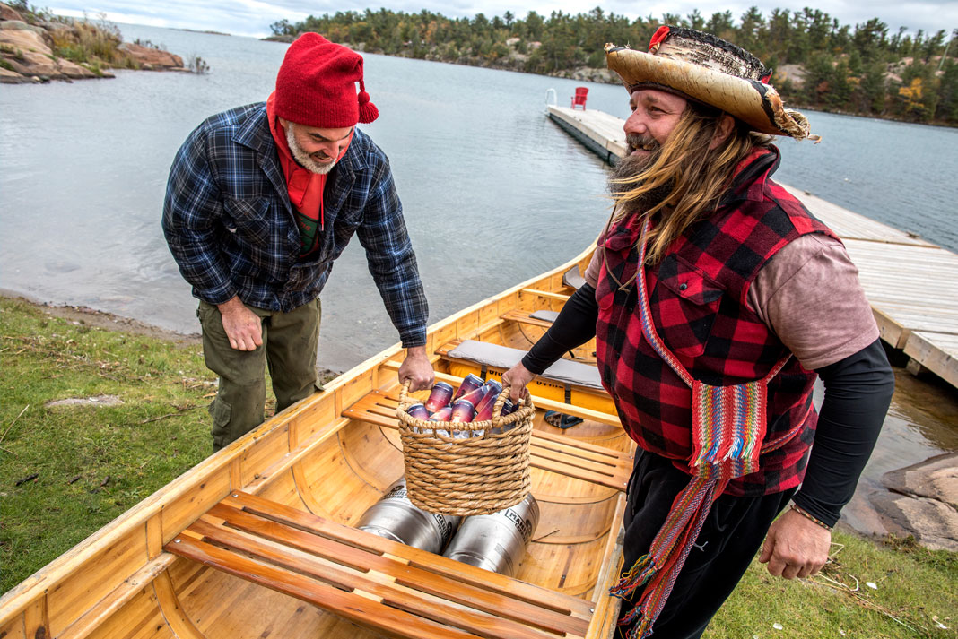 Modern day voyageur Mike Ranta [right] helped paddle the first batch of Killarney Cream Ale by Manitoulin Brewing Company from Little Current to the small community of Killarney, on Georgian Bay. This delivery inspired the Current To Killarney race. | Photo: David Jackson