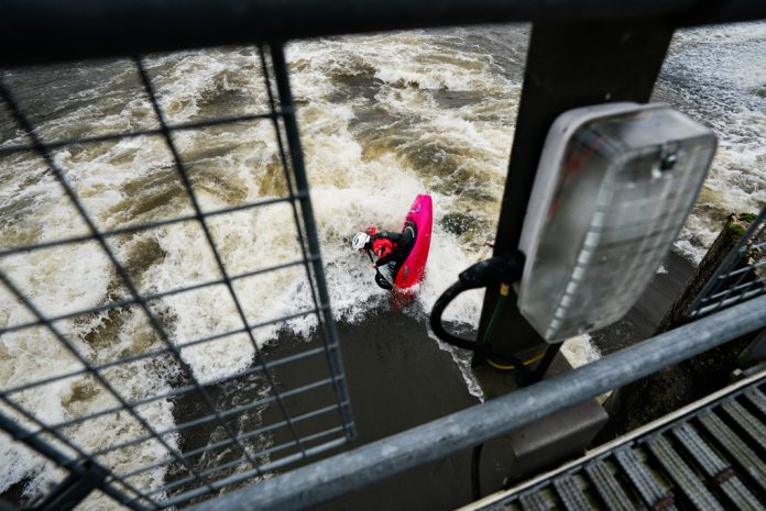 Paddler in pink kayak on a wave