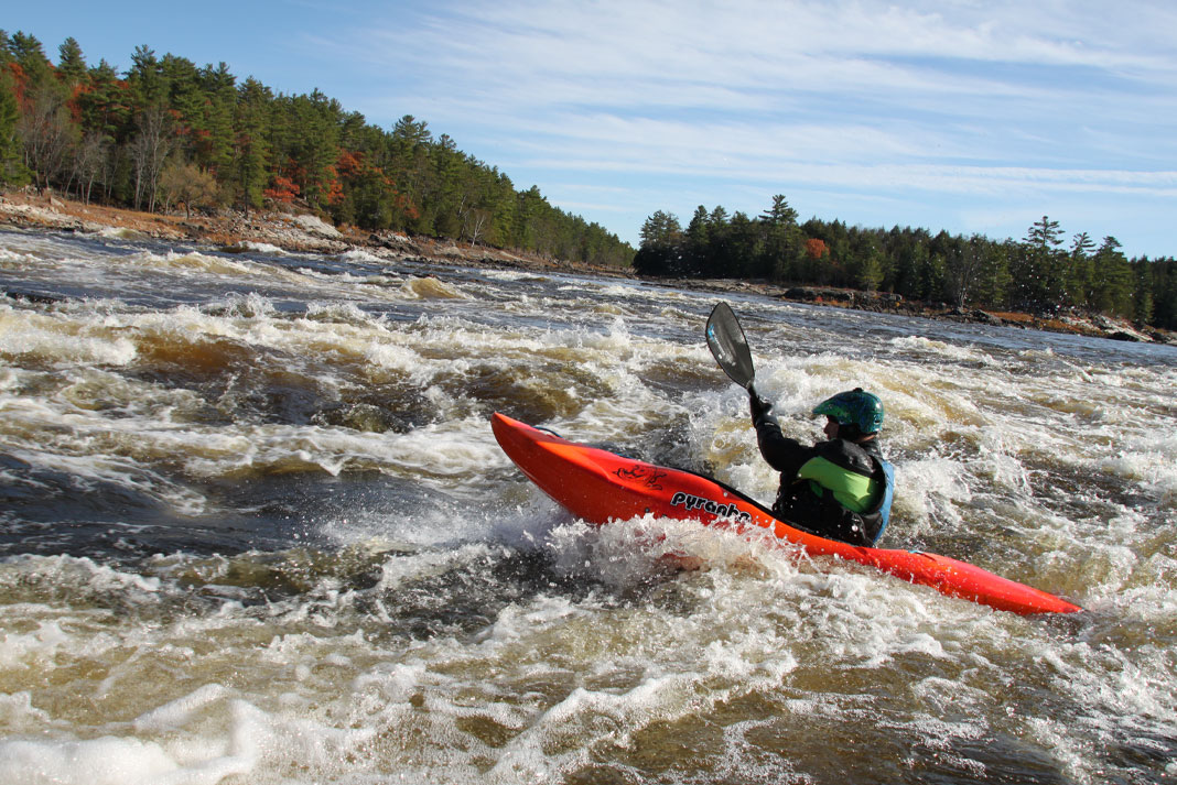 Person in red whitewater kayak