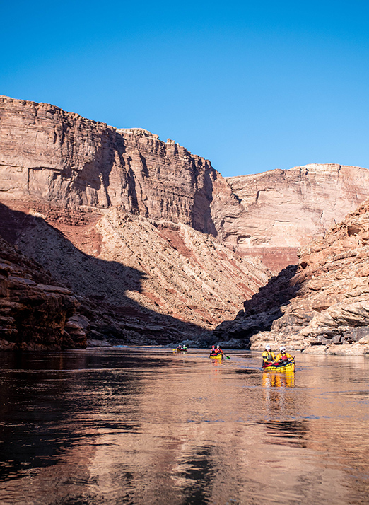 Canoes on river with canyon walls on either side