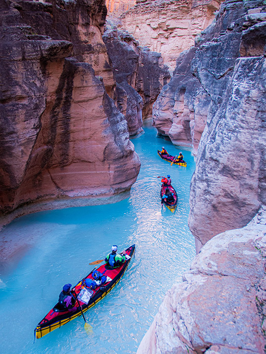 Canoes weaving through narrow canyon 