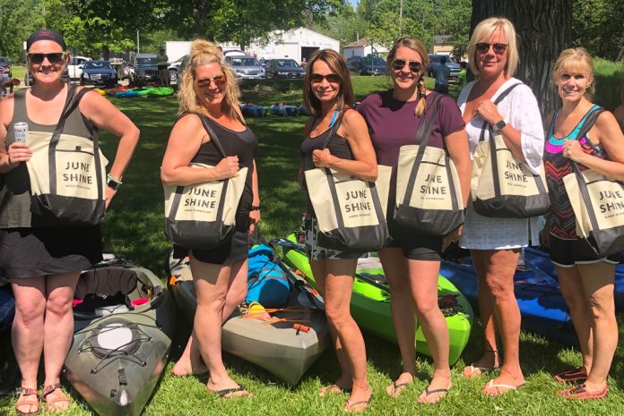Women standing with tote bags over their shoulders
