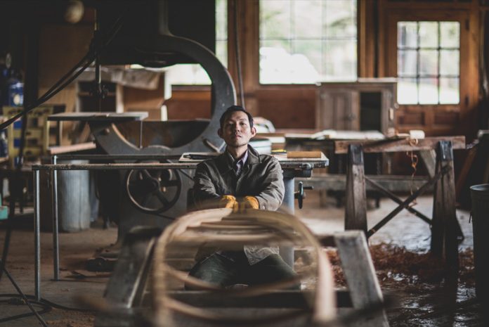 A man bends a frame for a skin on frame kayak.