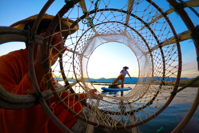 Worlds collide on Myanmar's Inle Lake where Traditional fishermen still travel in small, wooden, motorless boats. | Photo: Jim Martinello