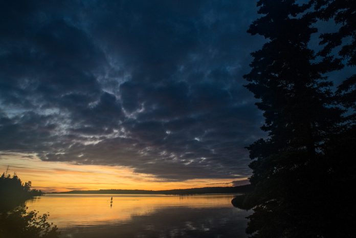 A single person paddleboards Lake Superior at Sunset