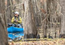 Man fishing from kayak in the trees