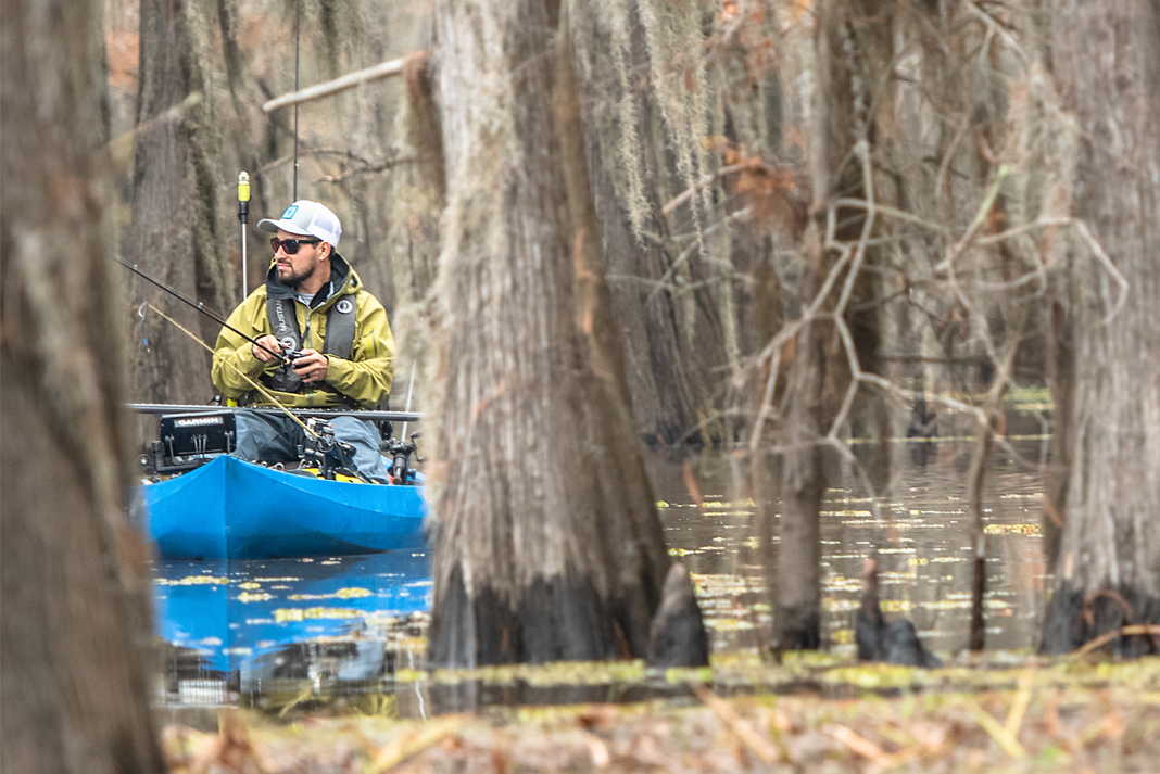 Man fishing from kayak in the trees