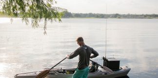 man rigging a sit-inside kayak for fishing