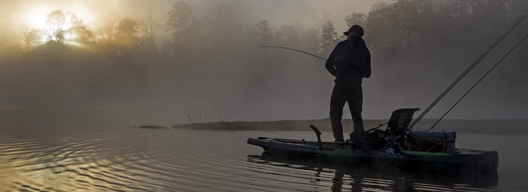 Person standing on fishing kayak and fishing