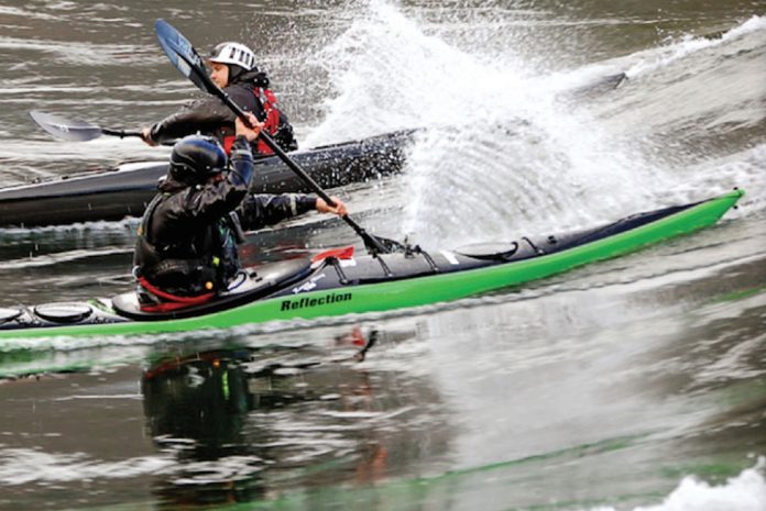 Two kayakers paddle in opposite directions in Sterling Kayaks Reflection kayaks