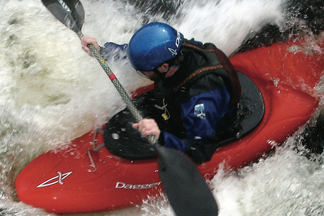 man paddles through whitewater rapids in a Dagger Juice kayak