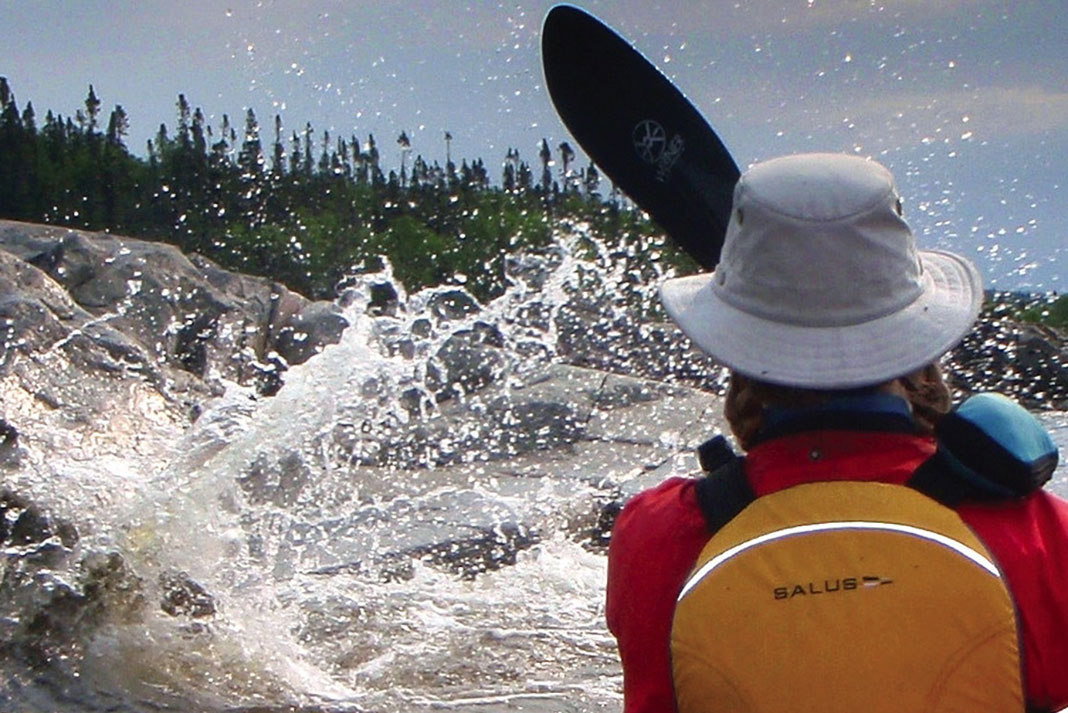 A person canoeing in rough water