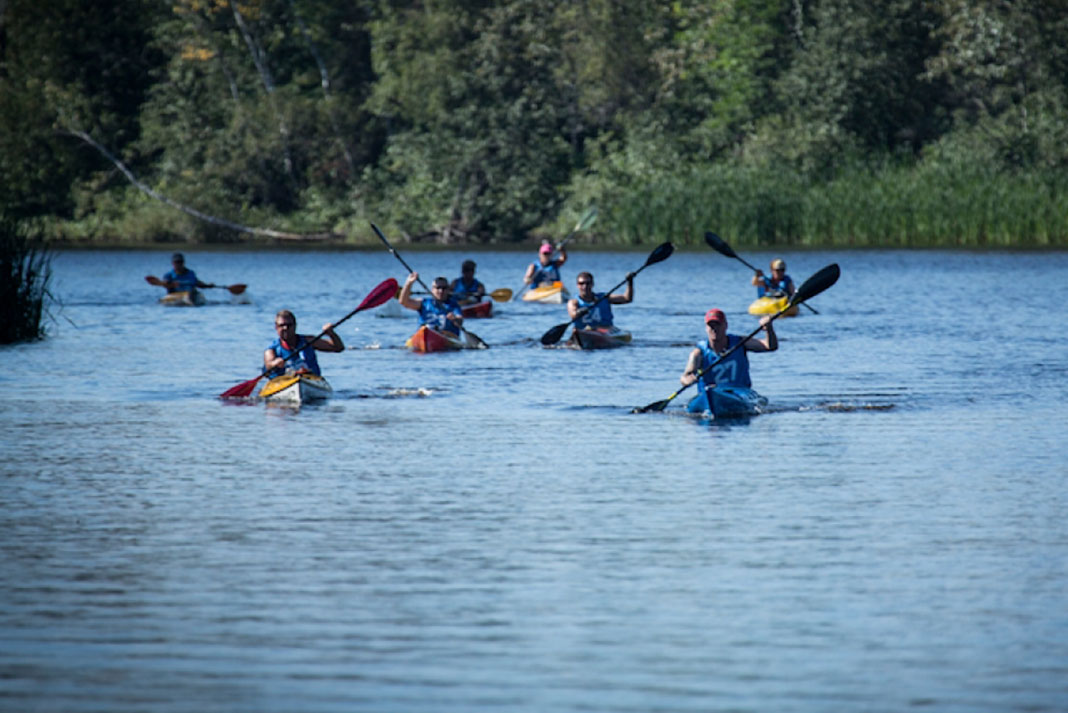 A group of racers paddling down a river