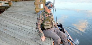 angler demonstrates how to get into a fishing kayak from a dock