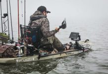 man paddles a fishing kayak with the best fish finder