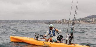 A kayak fisherman reels in a fish from a 2019 Hobie Mirage Outback kayak