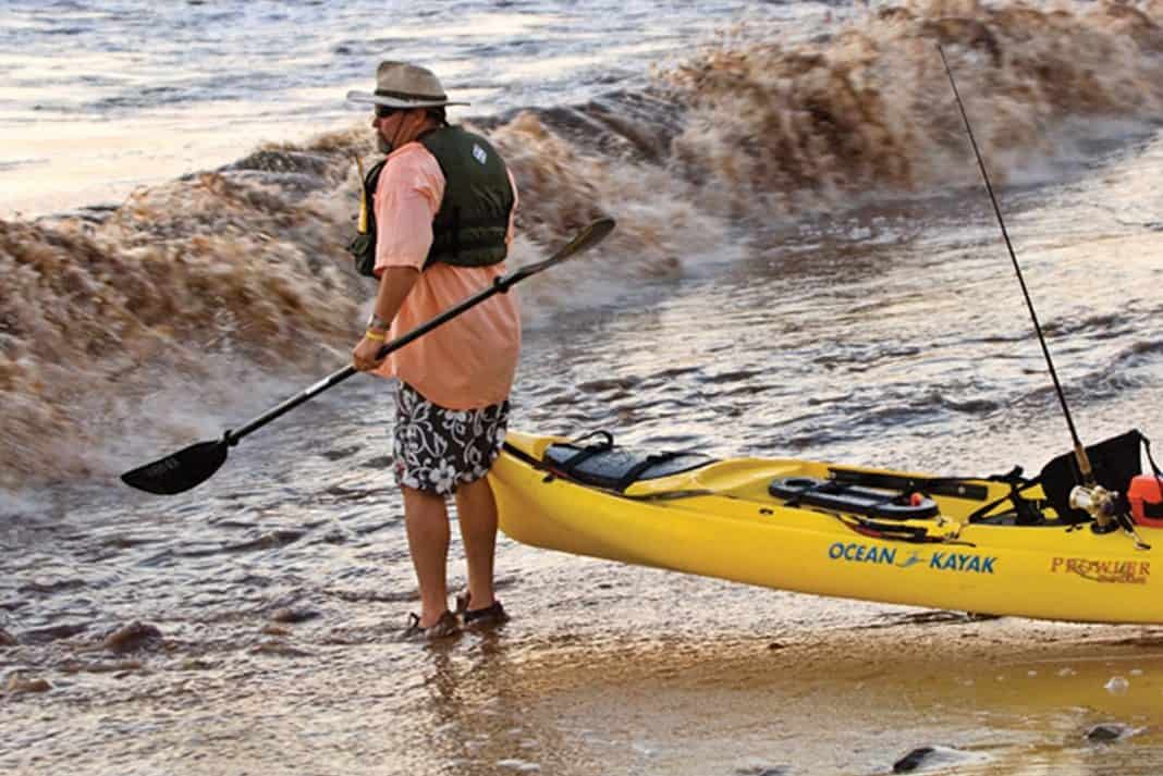 Kayak Angler Launching Kayak Into Ocean