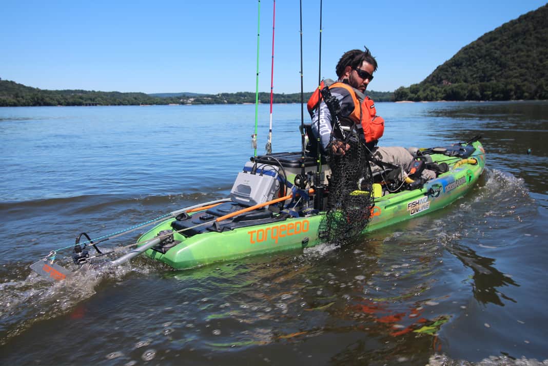 A man in his fishing kayak with aftermarket motor