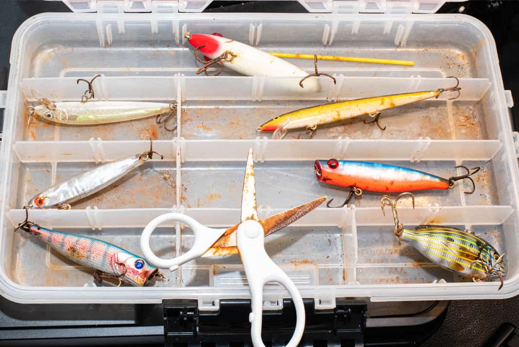Tackle box full of fishing lures with rust