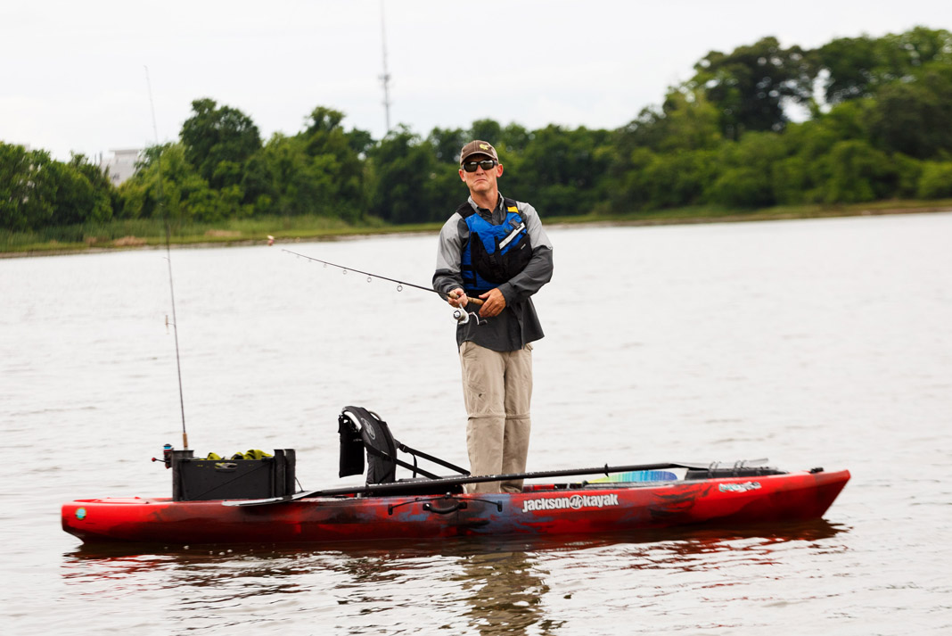 Man standing fishing in a Jackson Liska fishing kayak