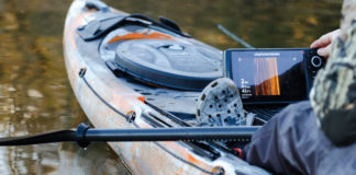 Man looks at a side-imaging sonar in his fishing kayak