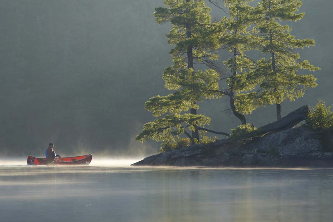 A solo canoeist crosses Mew Lake in Algonquin Park