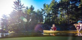 two people paddling a yellow canoe