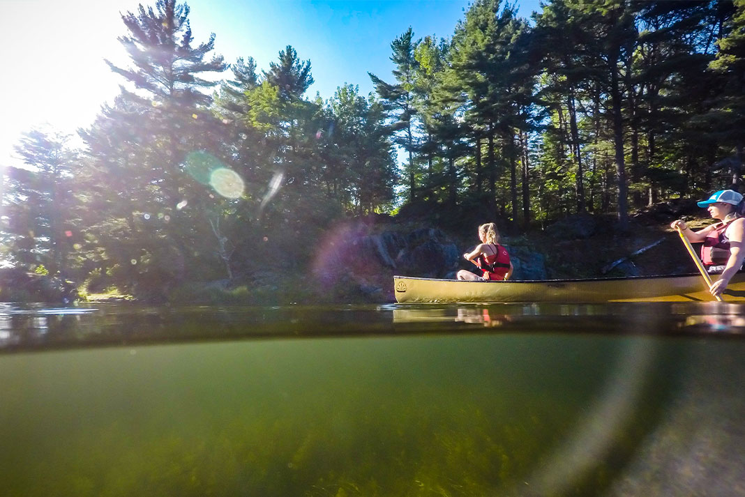 Two people paddling a yellow canoe