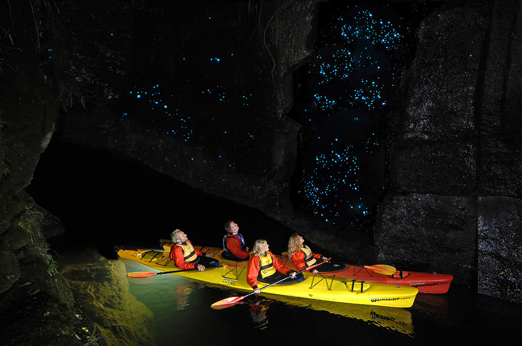Kayakers explore a glow worm cave tour