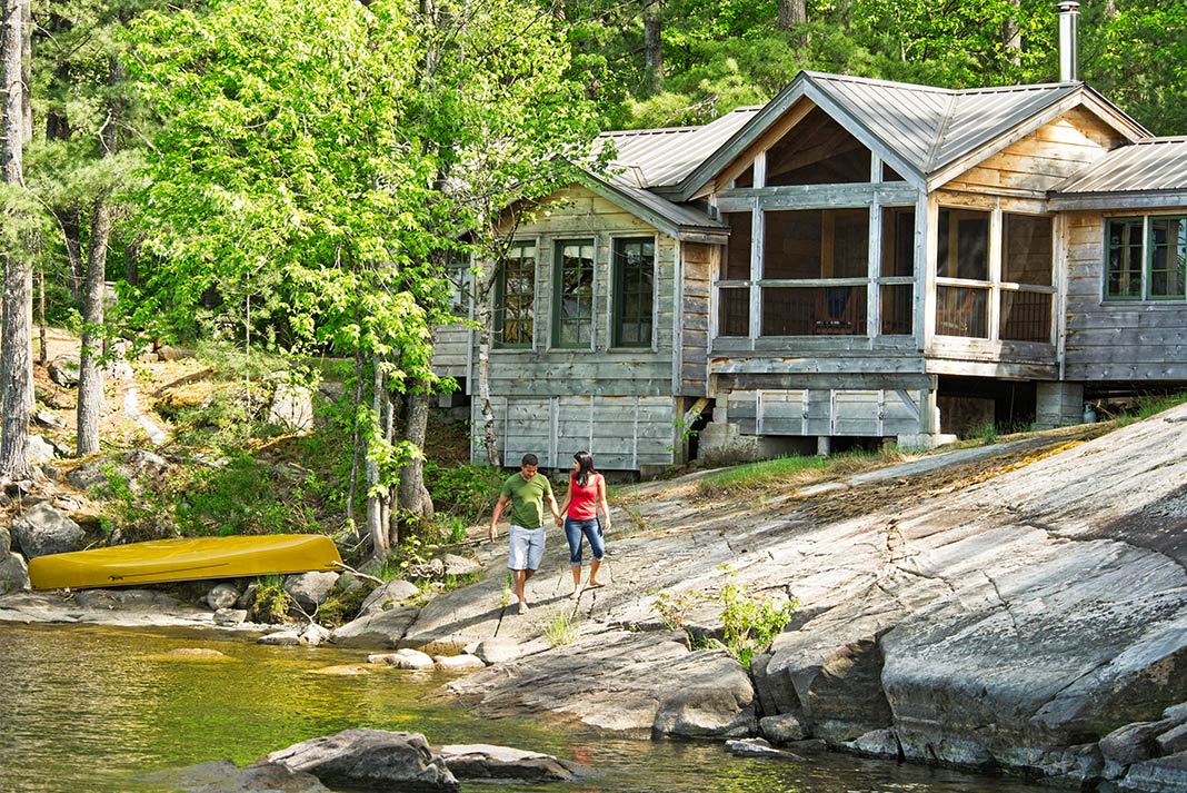 Cottage on a lake with couple in foreground