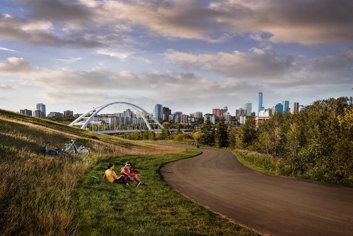 A view of Edmonton from afar with people relaxing in the forefront