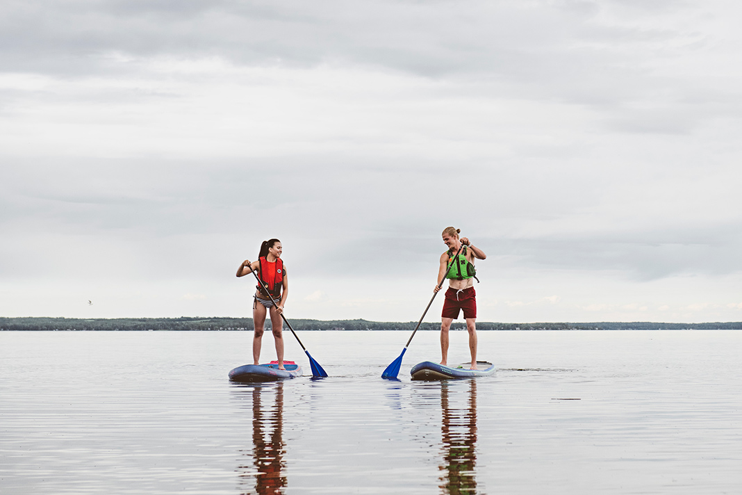 Two stand-up paddleboarders on Pigeon Lake