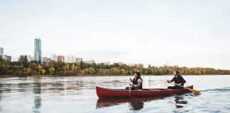 Canoeing down the river, city landscape in the distance