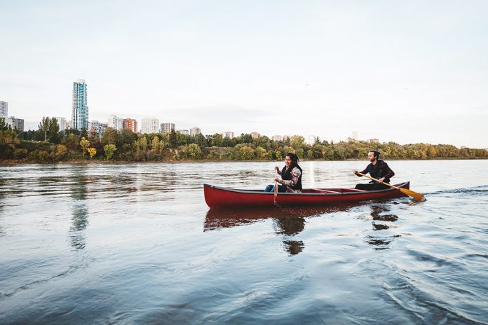 Canoeing down the river, city landscape in the distance
