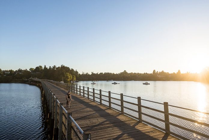 A man bikes on a boardwalk in Victoria, BC