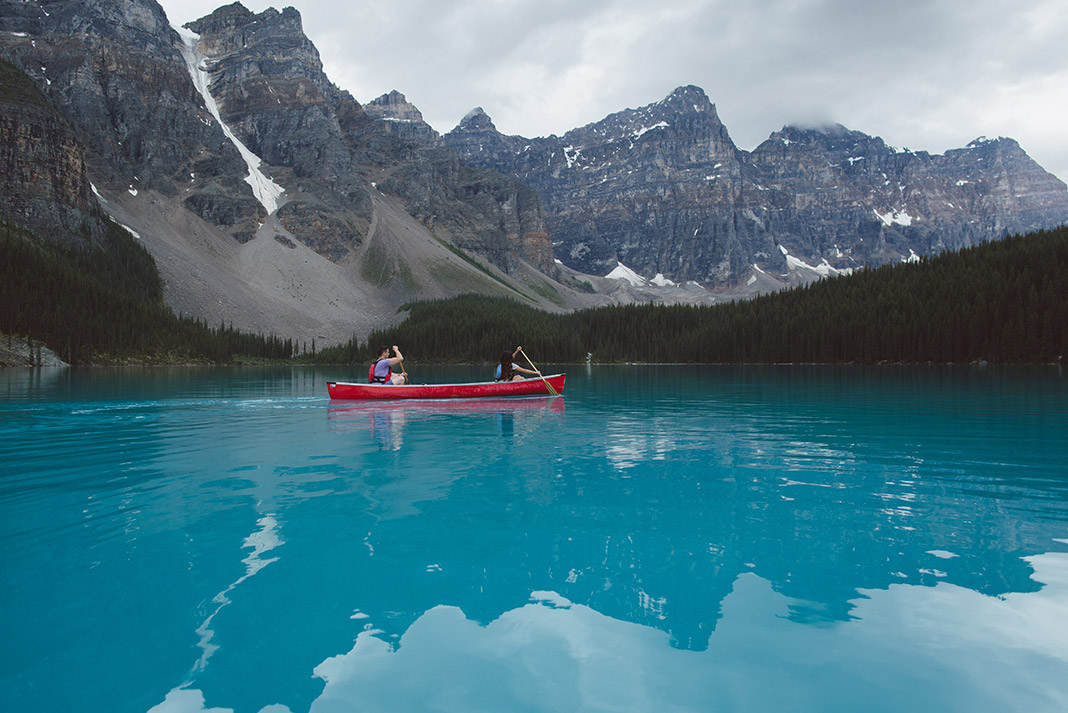 A red canoe on turquoise waters of Moraine Lake