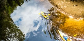 Two kayakers paddle on glassy waters in Mont Tremblant