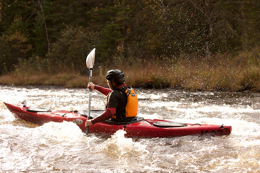A kayaker paddling through river rapids