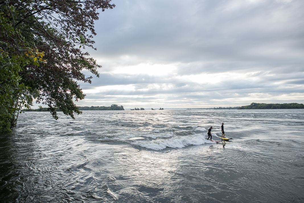 Two people surf on the St. Lawrence River near Montreal