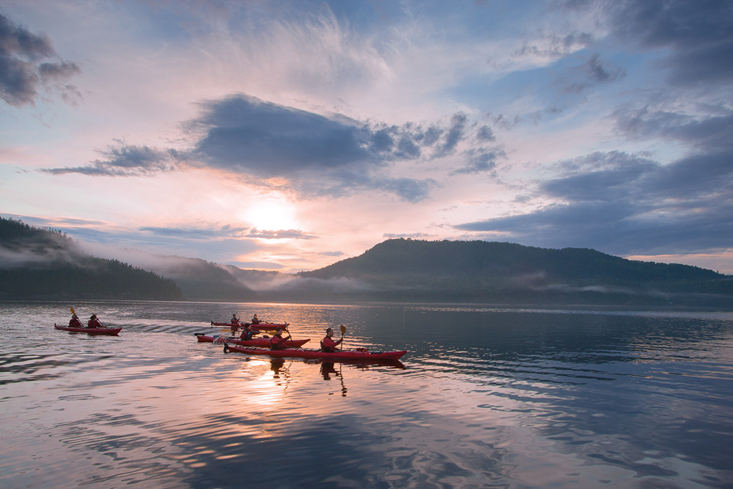 Kayakers enjoy the sunset shining on mountains and the water